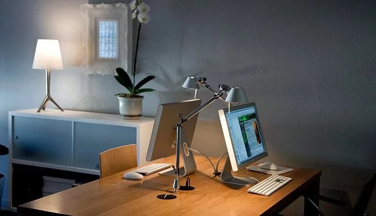 A casual home office setting with Monitors, desks and Lamps